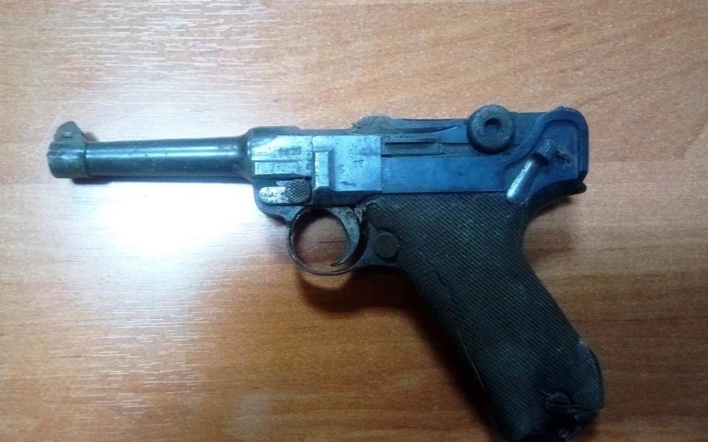 Stuletni pistolet w ścianie budynku