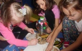 Przedszkolaki dokarmiają ptaki