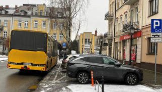 Osobówki na parkingu dla autokarów, autokar na jezdni