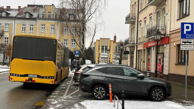 Osobówki na parkingu dla autokarów, autokar na jezdni