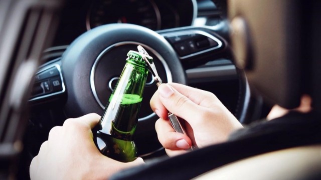 Pijany kierowca z piwem w ręce