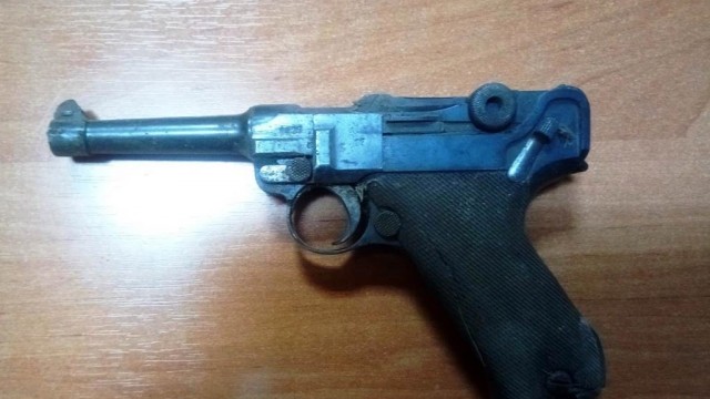 Stuletni pistolet w ścianie budynku